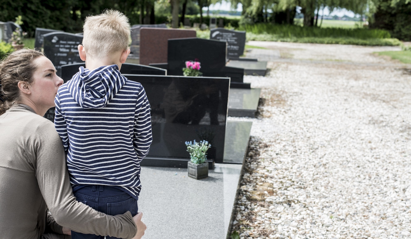 Sorgerechtsverfügung: Kind und Mutter stehen vor dem Grab des Vaters.