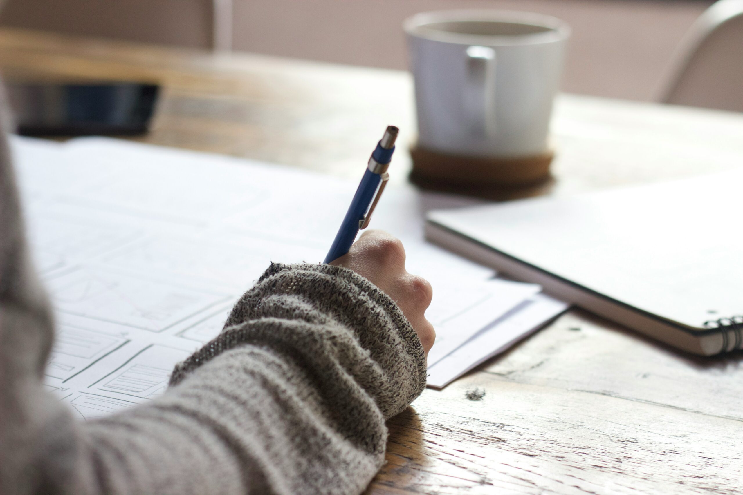 Person mit Stift am schreiben.